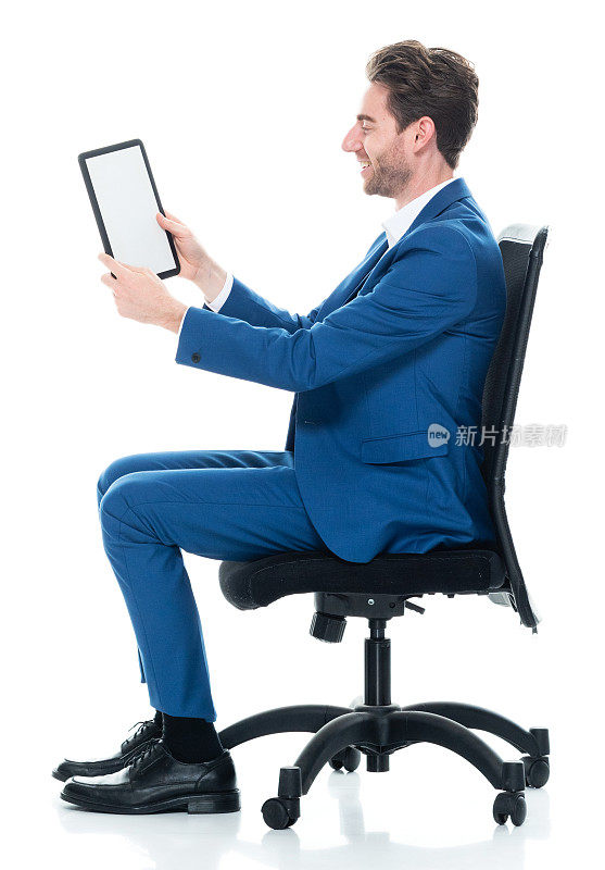 白人男性商务人士坐着，穿着商务服装，使用触摸屏
