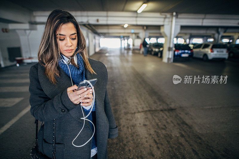 一名女子在地下车库使用智能手机