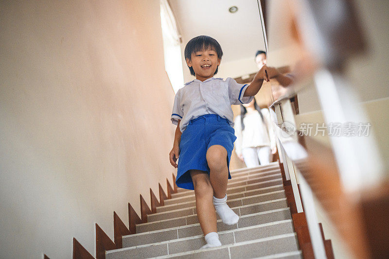 自信的中国小男孩在家里下楼梯