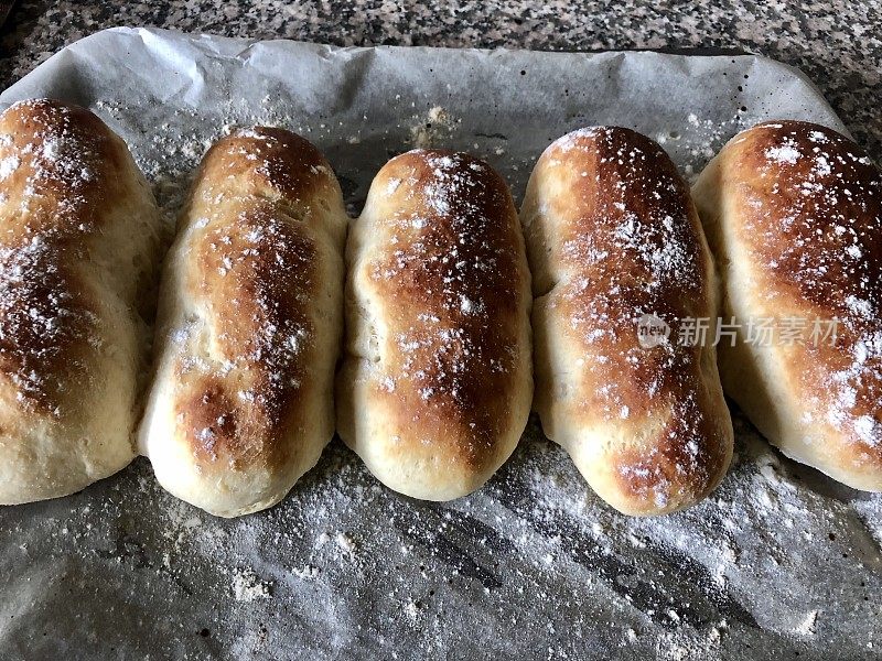 新烤的，自制的白面包桥卷撒上白面粉，向上看手指卷