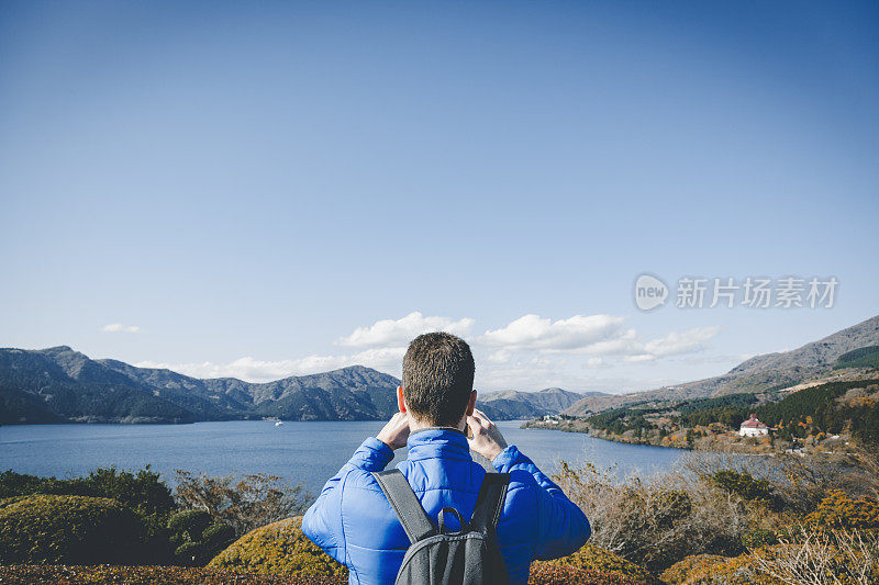 一名男子在登山时用智能手机拍照