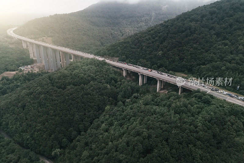 在高峰时间开车穿过交通堵塞。2019冠状病毒病大流行期间，首都城市入口处出现严重交通堵塞的公路桥鸟瞰图。忙碌的生活，俯视图，城市景观。