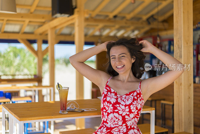 海滩酒吧里的漂亮快乐的年轻女人。