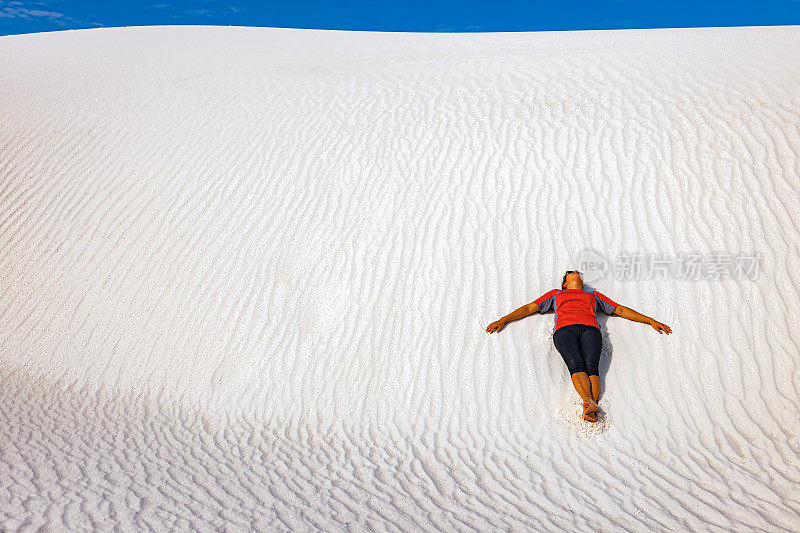 在美国新墨西哥州白沙上休息的女人