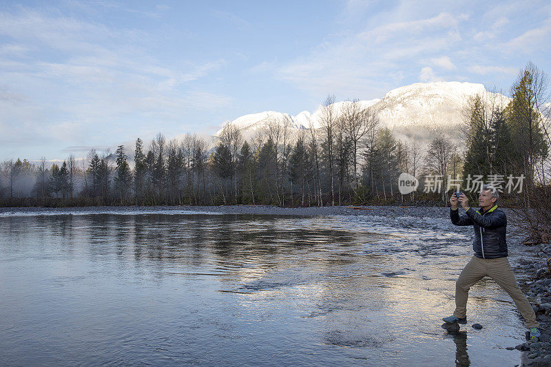 日出时分，一名男子用手机拍摄湖面