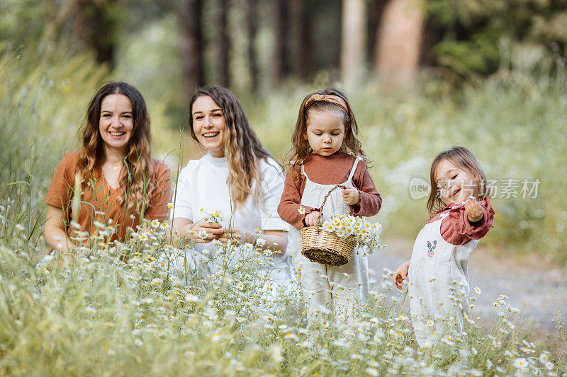 快乐的妈妈和小女孩们在采花