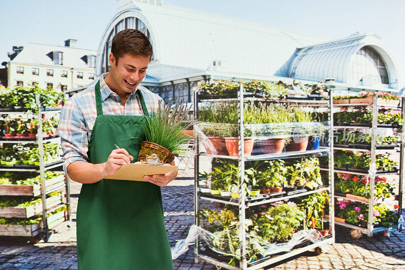 白人男性植物学家园艺穿着围裙和持有植物