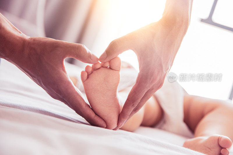婴儿的脚在父亲的手中做成心形