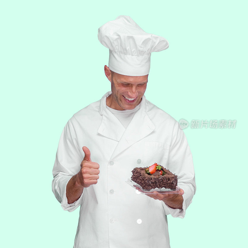 白人男厨师穿着夹克衫拿着蛋糕在有色背景前