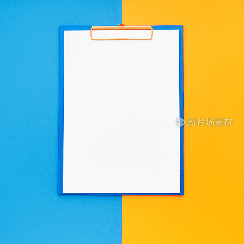 空白剪贴板模型在蓝橙色的背景。俯视图，复制空间。