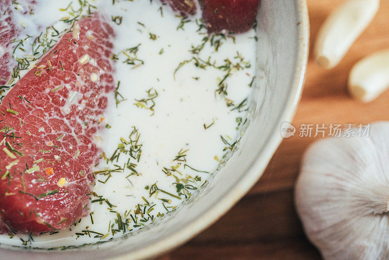 生牛肉浸在牛奶和香料中