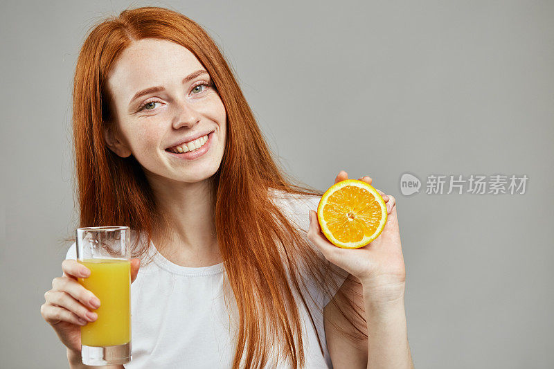 微笑着喝橙汁的漂亮女孩