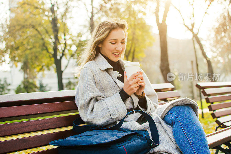 快乐的女人放松在公园喝一杯咖啡库存照片