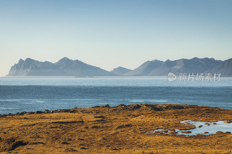 在阳光明媚的日子里，冰岛东部的山景和海洋美景