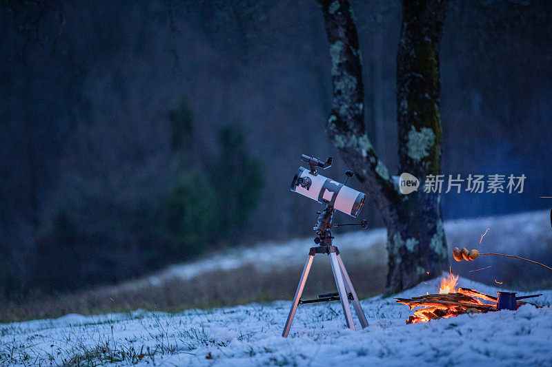 冬日黄昏时篝火旁的望远镜
