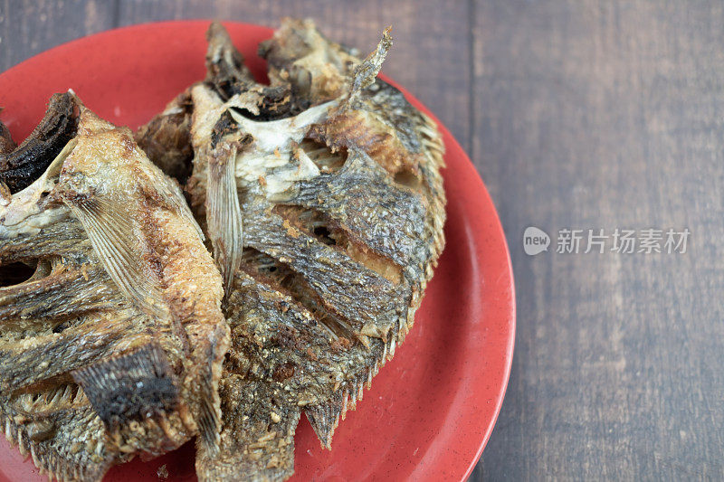 罗非鱼炸熟后放在红碟上即可食用。泰式自制食物的概念