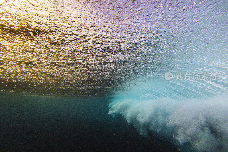 在大海下，金色的光与破碎的波浪