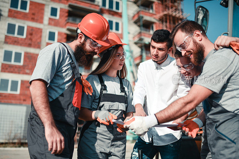 微笑的胡子工人，女土木工程师和男建筑师讨论建筑计划
