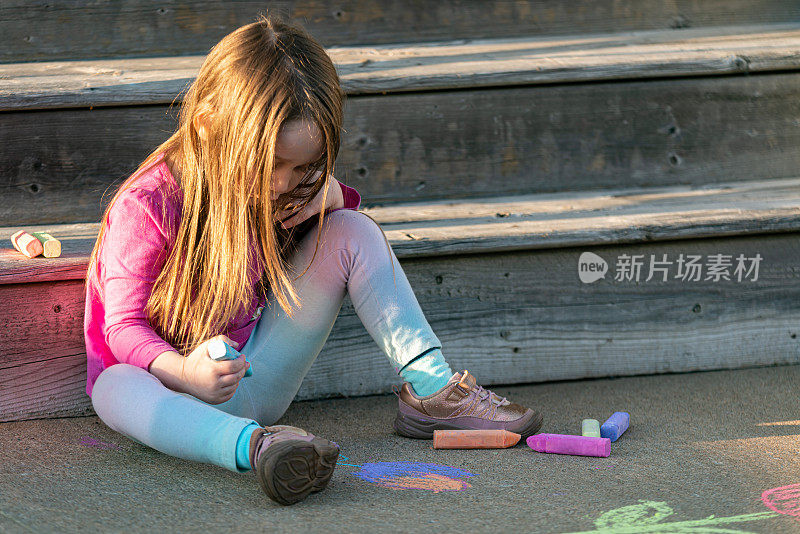 女孩在前廊用粉笔画画