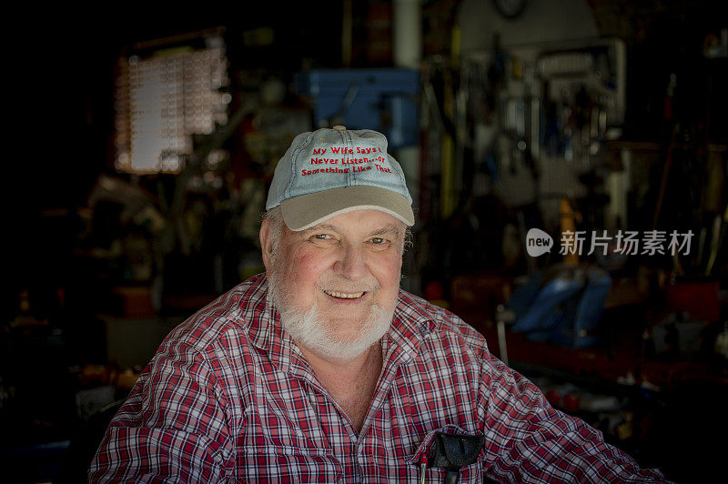 厚脸皮的退休老人微笑着炫耀他的帽子。
