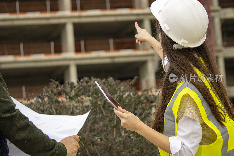 女建筑师在建筑工地与数字平板电脑