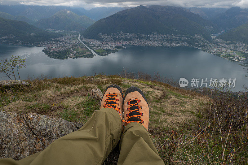 人的脚在山顶俯瞰湖面