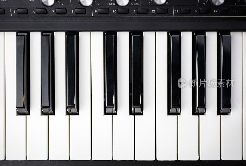 模拟合成器钢琴键盘平放。录音棚中用于电子音乐制作的专业合成器。钢琴乐器上的黑白键