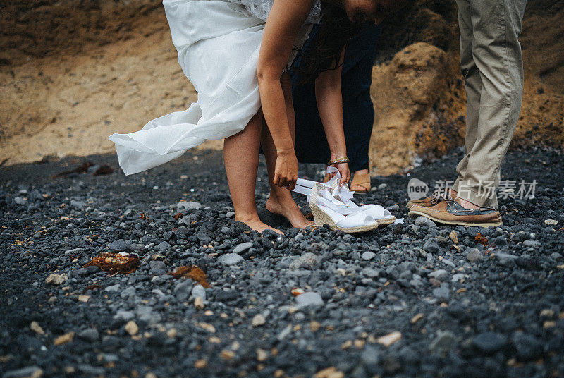 新娘在岩石海滩结婚前穿上高跟鞋