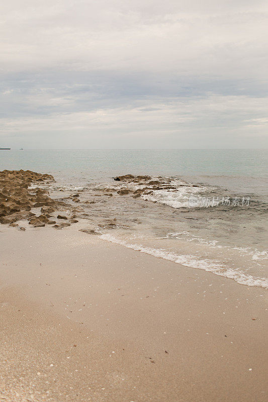 2021年8月，在新冠病毒三角洲变种崛起期间，海浪拍打着佛罗里达州辛格岛的空岩石海滩海岸线