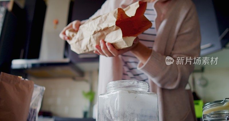 一位妇女正在厨房的食品储藏室里整理食物