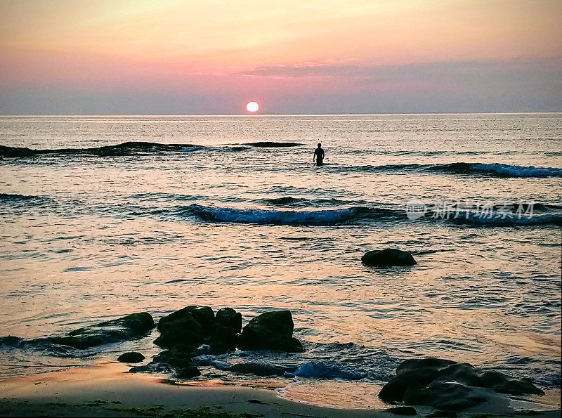 日落时在海里游泳