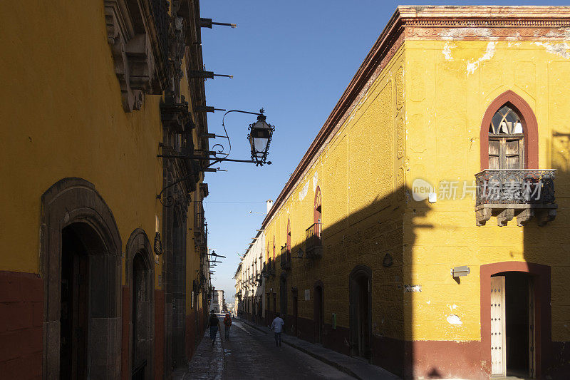 墨西哥圣米格尔德阿连德的街道，日出时带有阳台的黄色殖民风格房屋
