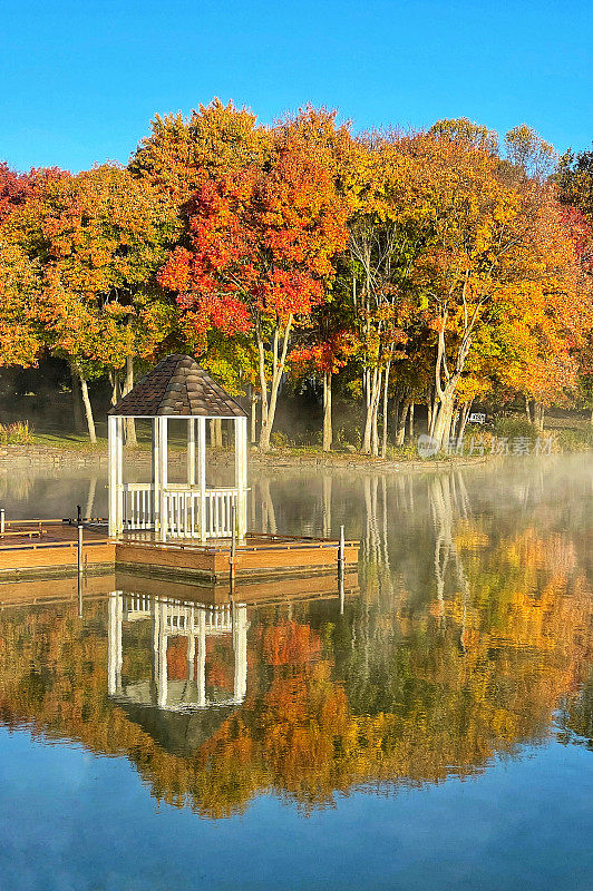 在宾夕法尼亚州切斯特县的湖边，秋天有凉亭和五颜六色的树叶