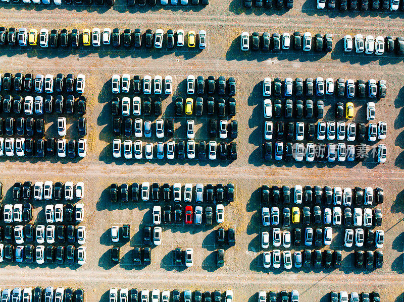 鸟瞰图的汽车停放在停车场。新车经销商库存进出口业务全球商业，汽车及汽车行业全球物流运输。