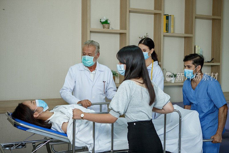一群医生和护士用轮床把病人抬到医院的急诊室。