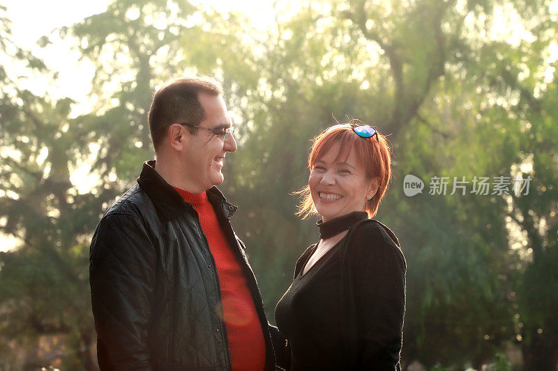 户外肖像中年已婚高加索夫妇在阳光明媚的绿色花园