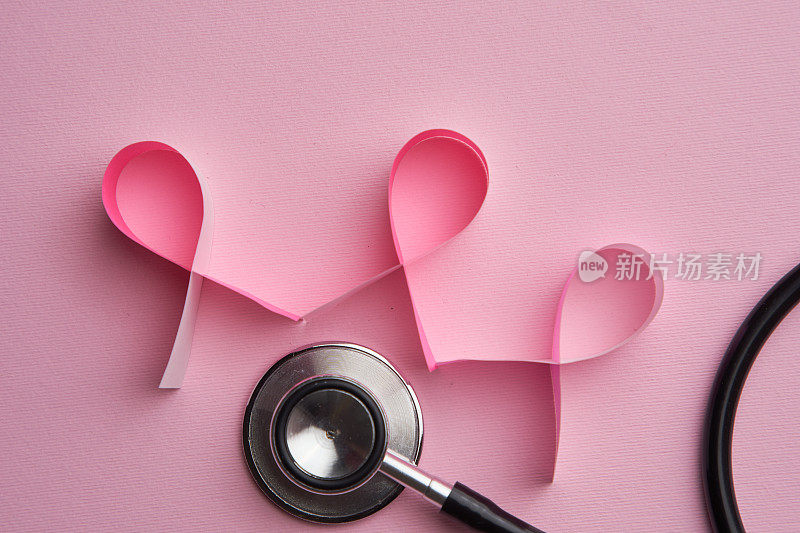 粉红丝带乳癌意识符号和听诊器与粉红背景