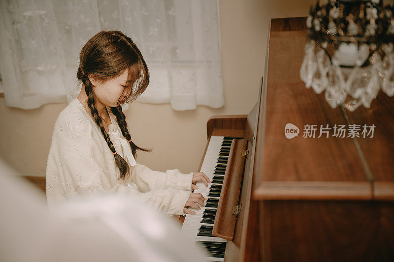美丽的亚洲女孩弹钢琴