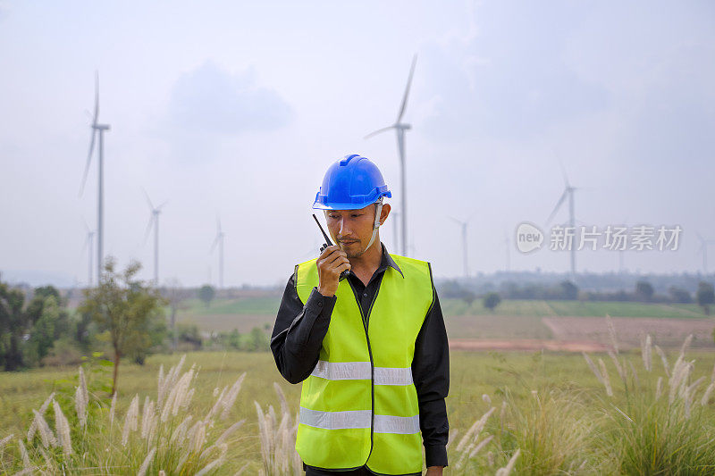 在发电厂工作的蓝领工人。风车。