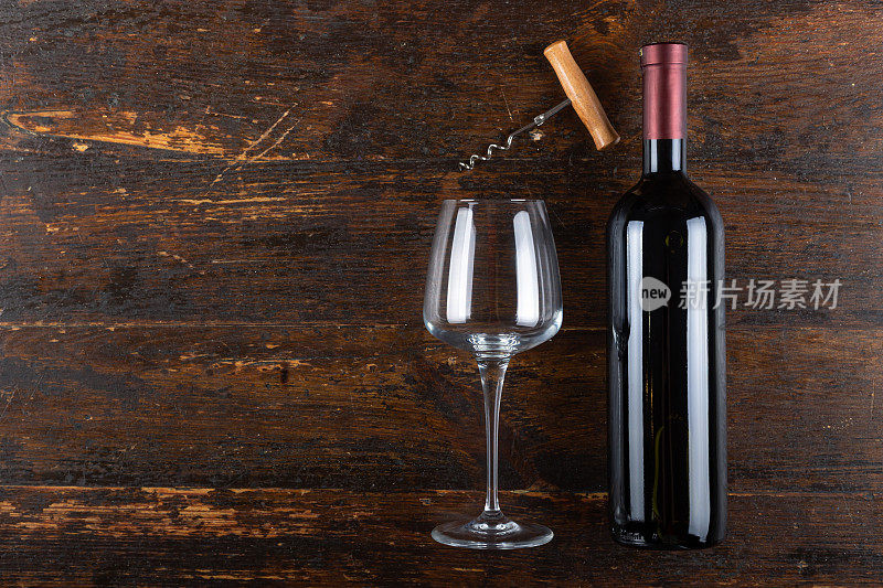 红酒酒瓶，空玻璃和开塞钻在木制背景上。酒精饮料。
