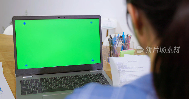女性使用绿屏笔记本电脑