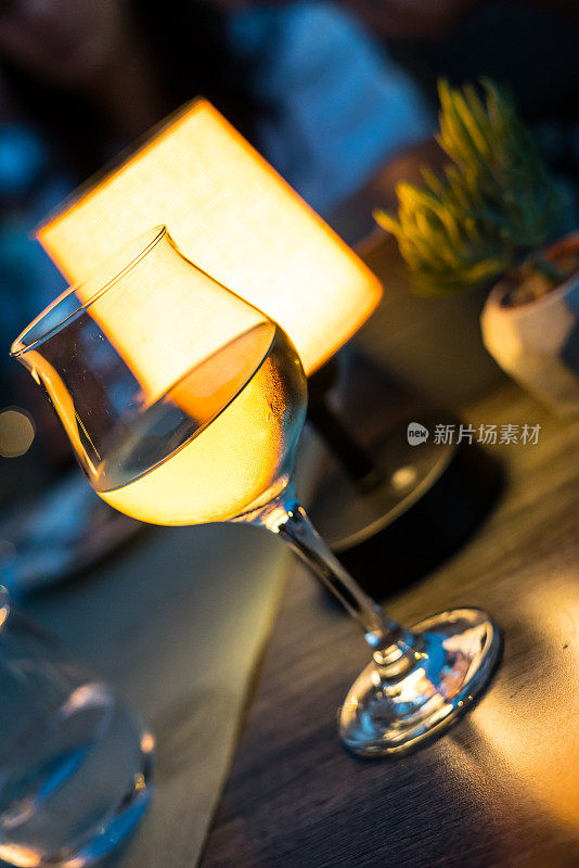 白葡萄酒是在晚上的杯子集中前景豪华的氛围