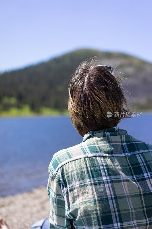 坐在山间湖边的女人