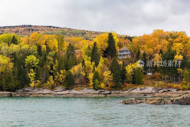 房子隐藏在森林在加拿大的湖上，在秋天