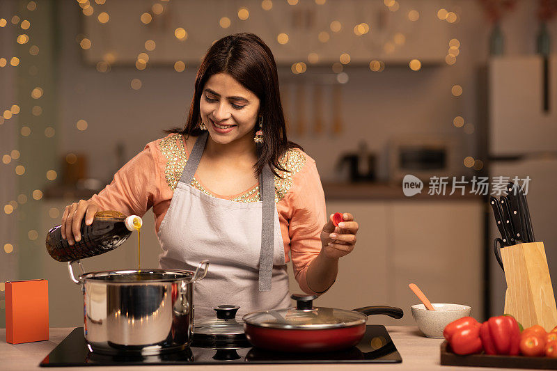 快乐的女人享受做饭在厨房，股票照片