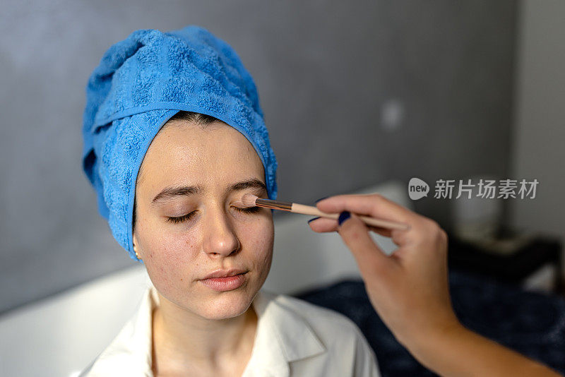 图为，一名女子正在家中接受女化妆师的面部护理。