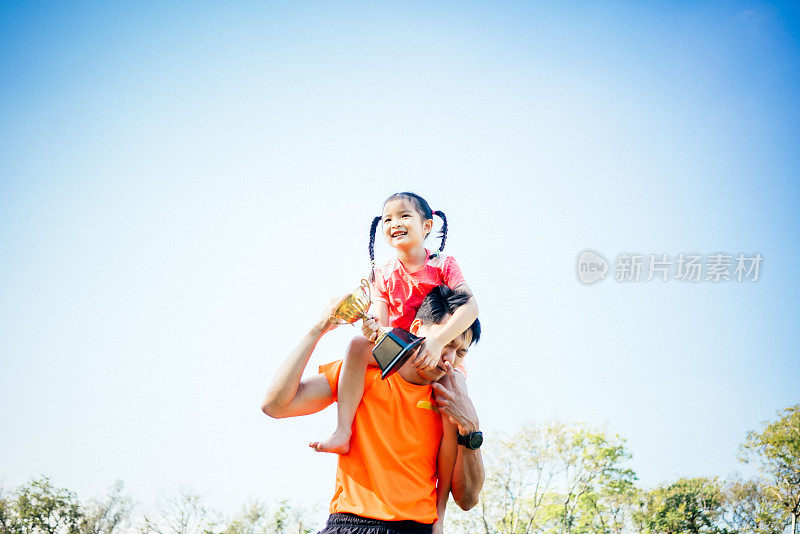 父女俩手捧奖杯庆祝