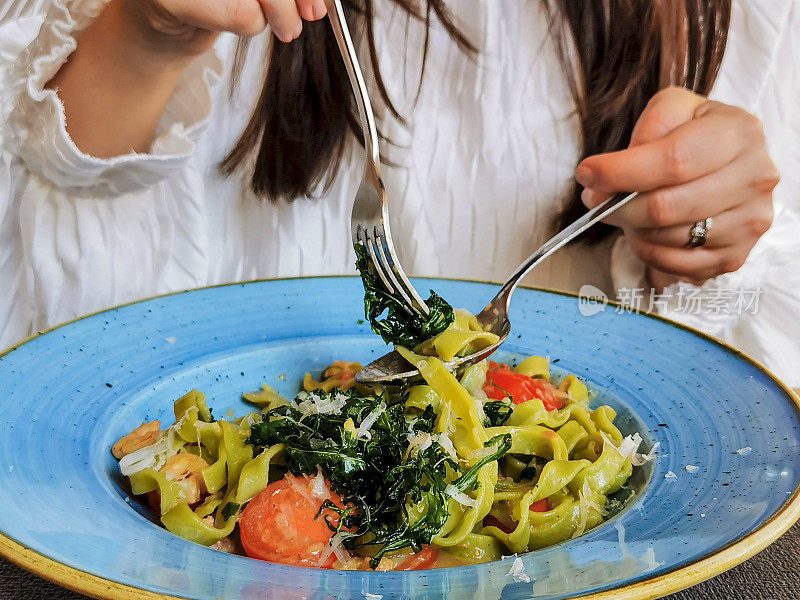 特写镜头的女人在意大利餐厅吃意大利面。