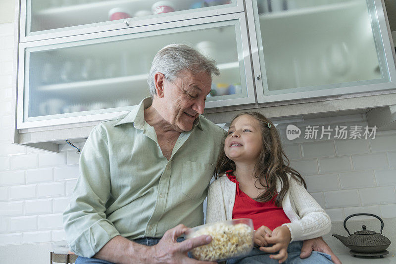 幸福的老人和孙女在家里的厨房合影