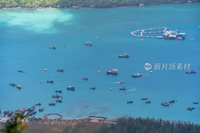 越南孔岛本丹港，湛蓝的大海，蓝天山和五颜六色的船只。